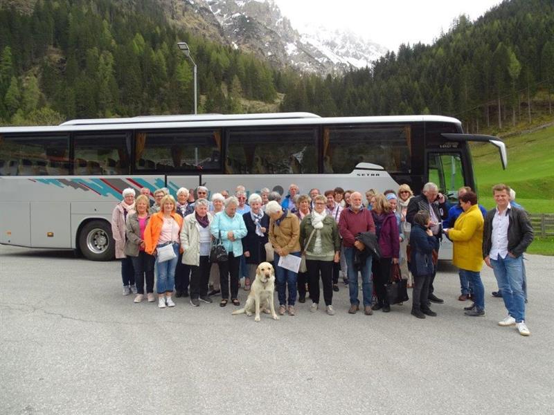 Eine Gruppe von Menschen posiert für ein Foto neben einem Bus